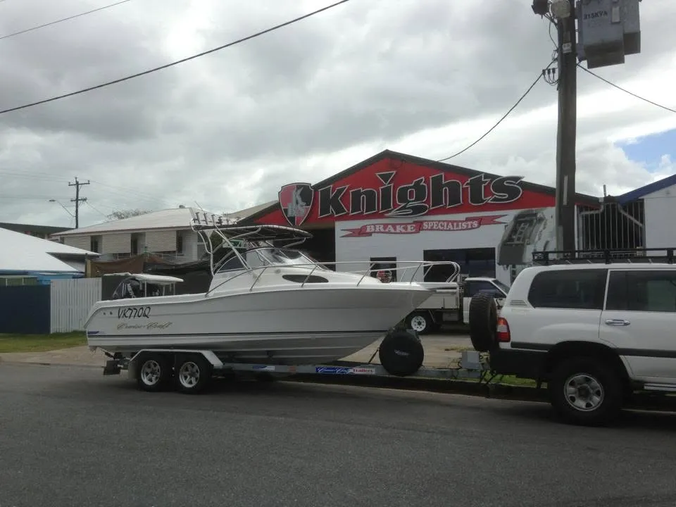 Boat and trailer being towed past the Knights Brake Specialists workshop in Cairns